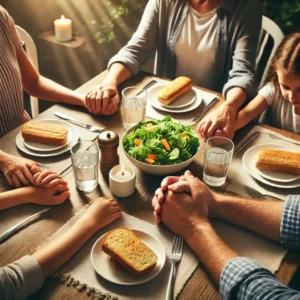 A family sitting at a dinner table hands joined i